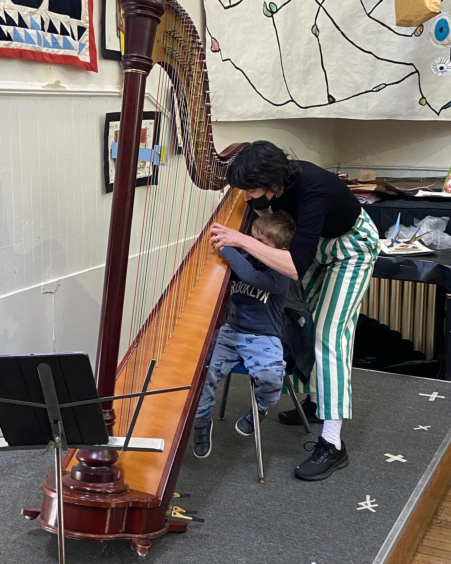 Esther teaching harp to young child.